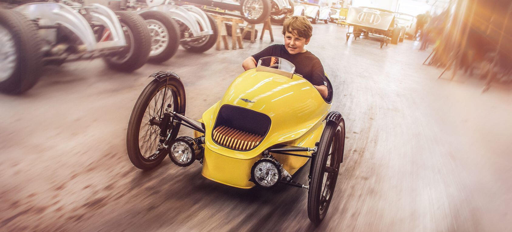 En pojke kör genom en garage i en gul bil. (AI text)