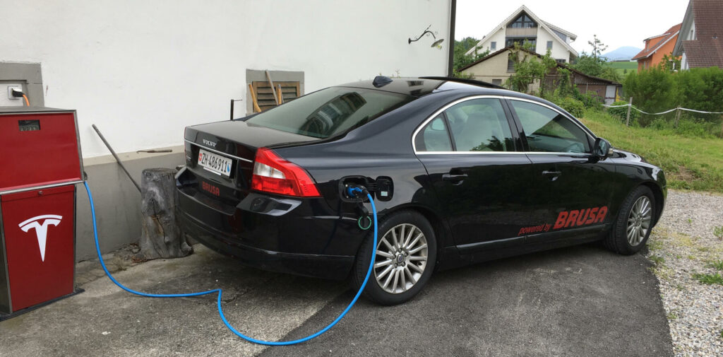 En bil är uppkopplad till en elladdare. (AI text)