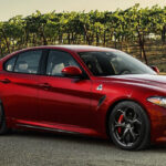 En röd Alfa Romeo GT kör nedför en landsväg. (AI text)