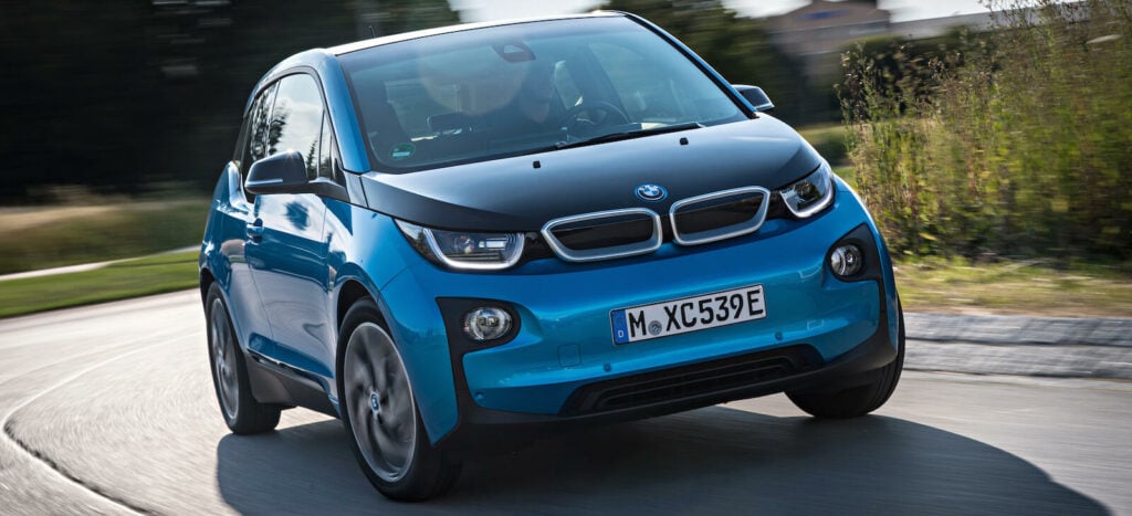En BMW i3 kör på en landsväg. (AI text)