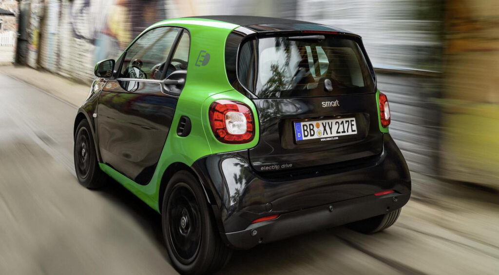 En smart fortwo kör nedför en stadsgata. (AI text)