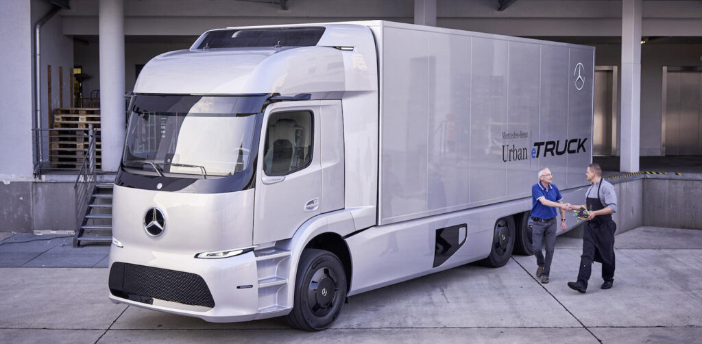 En Mercedes-Benz eTron-vagn parkerad framför ett byggnad. (AI text)