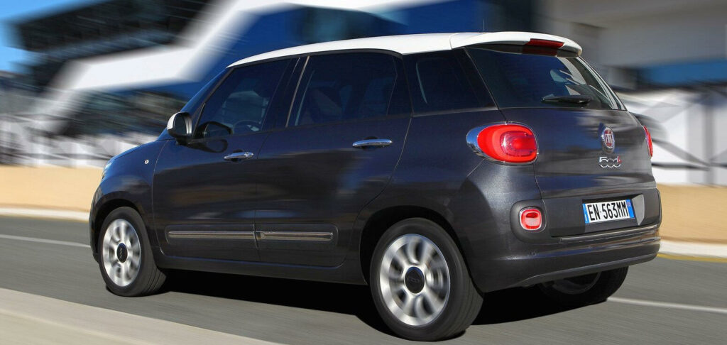 En svart Fiat 500 kör nerför en väg. (AI text)