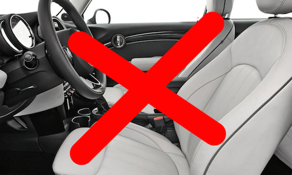 En vit Mini Cooper med en röd "No" skylt på instrumentbrädet. (AI text)