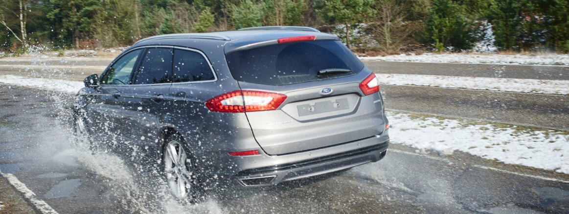 En bil kör på en snöig väg. (AI text)