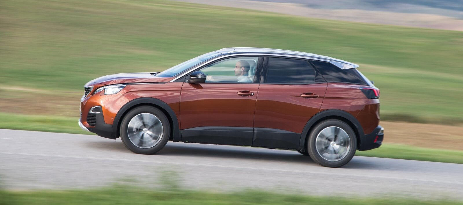 En bil kör genom landsbygden längs en landsväg. (AI text)