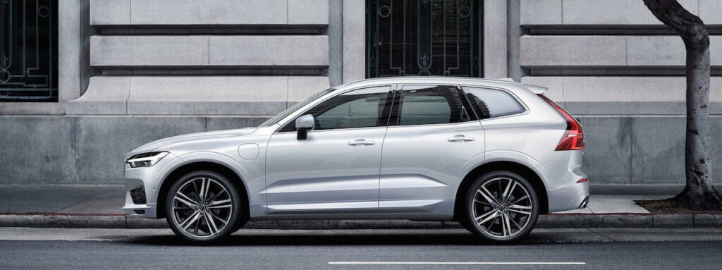 En vit Volvo XC90 SUV parkerad framför ett byggnad. (AI text)