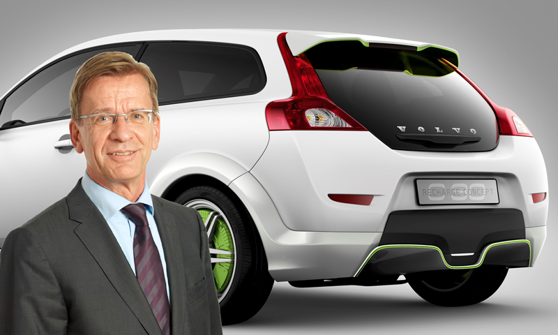 En man i kostym står bredvid en vit bil. (AI text)