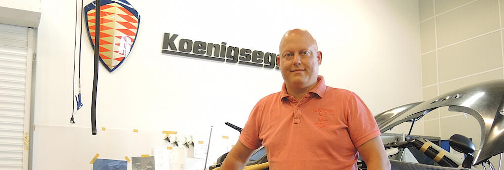 En man står framför en bil. (AI text)