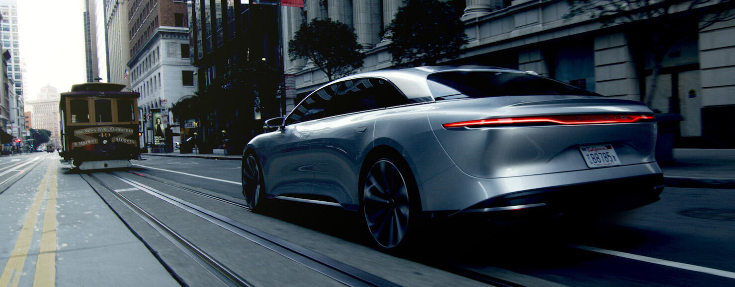 En framtida bil kör nerför en stadsgata. (AI text)