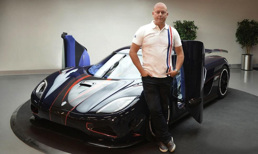 En man står bredvid en Koenigsegg. (AI text)