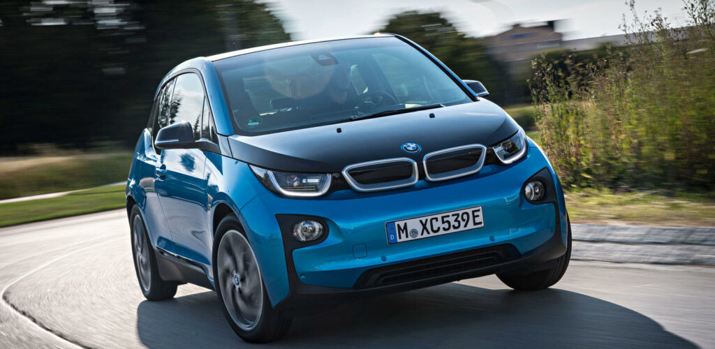 En BMW i3 kör på en landsväg. (AI text)