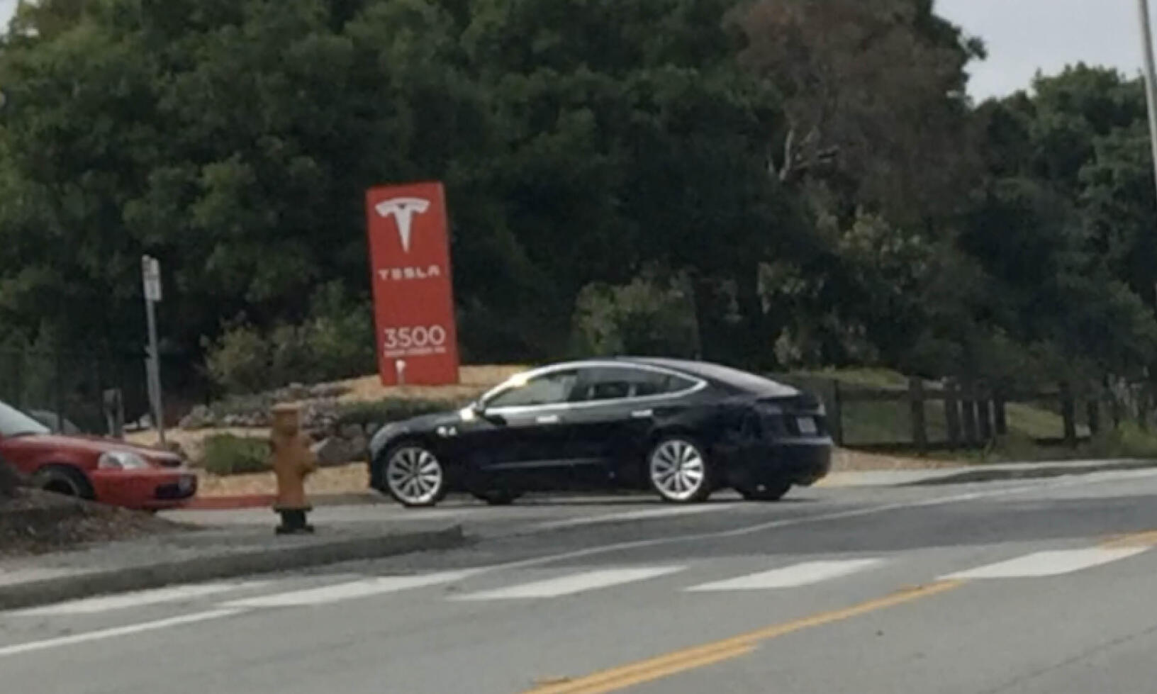 Tesla Model S parkerade vid en stoppskylt. (AI text)
