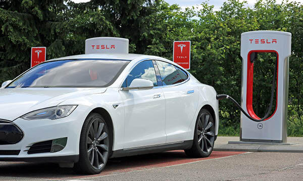 Tesla Model S laddar vid en Tesla-station. (AI text)