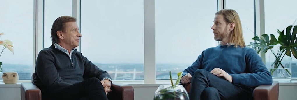 Två män pratar i en rum. (AI text)