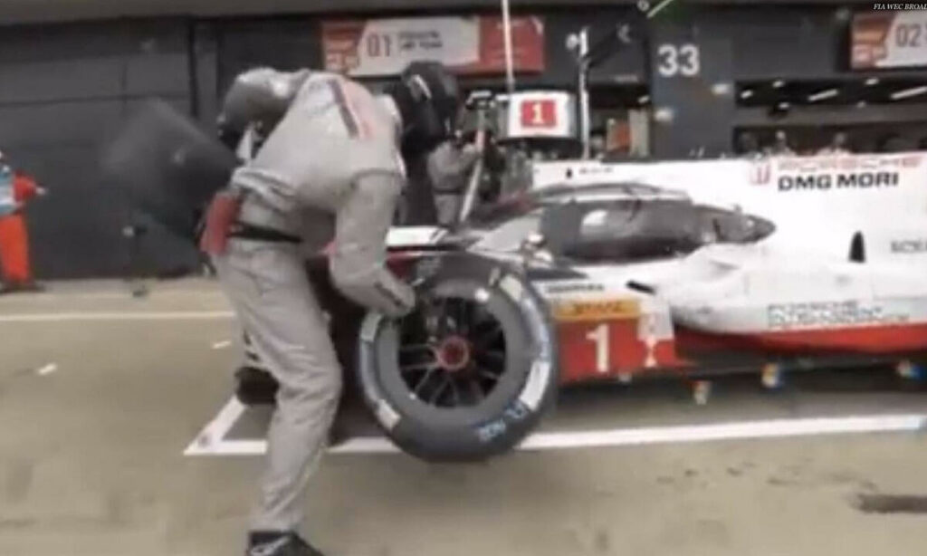 En racerbil arbetas på av en mekaniker. (AI text)