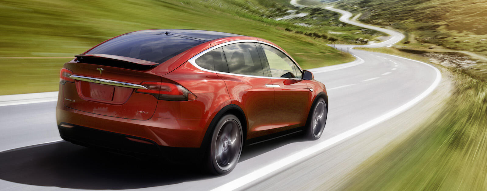 Tesla Model X kör nerför en bergsväg. (AI text)