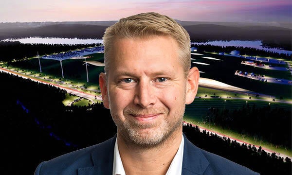 En man i kostym står framför ett sjö. (AI text)