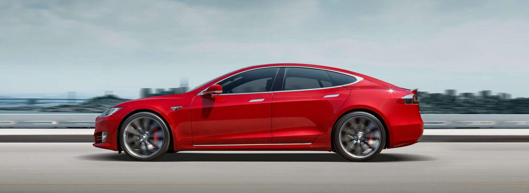 En röd Tesla Model S kör ner en väg. (AI text)