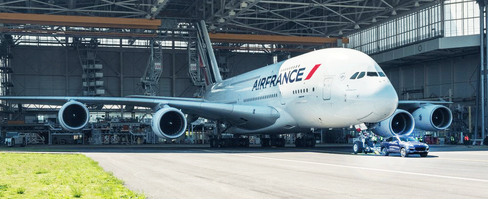 Ett stort flygplan står i ett hangar. (AI text)