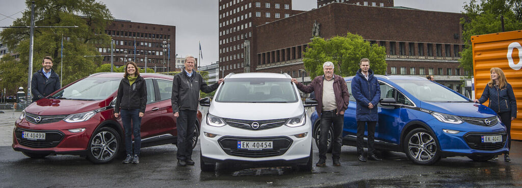 En grupp personer står bredvid en bil. (AI text)