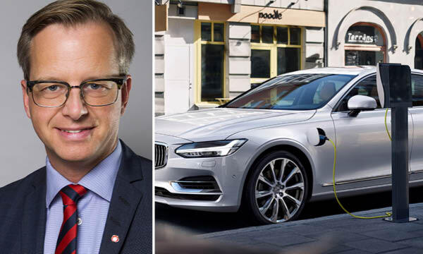 En man i glasögon laddar tillsammans med en man i kostym sin elbil. (AI text)