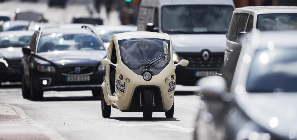 En bil kör ner en stadsgata. (AI text)