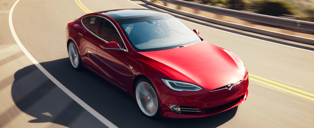 En Tesla Model S kör på en väg. (AI text)