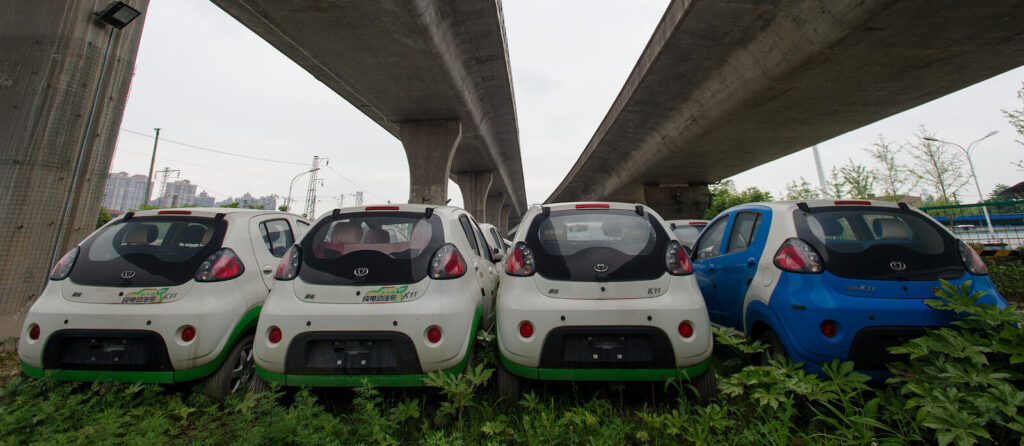 Här, under en motorvägsbro i östra Kina, står mängder av oanvända elbilar för att tillverkaren skulle kunna fuska till sig elbilssubventioner. Foto: Feature China/Barcroft Images/Barcroft Media/Getty Images