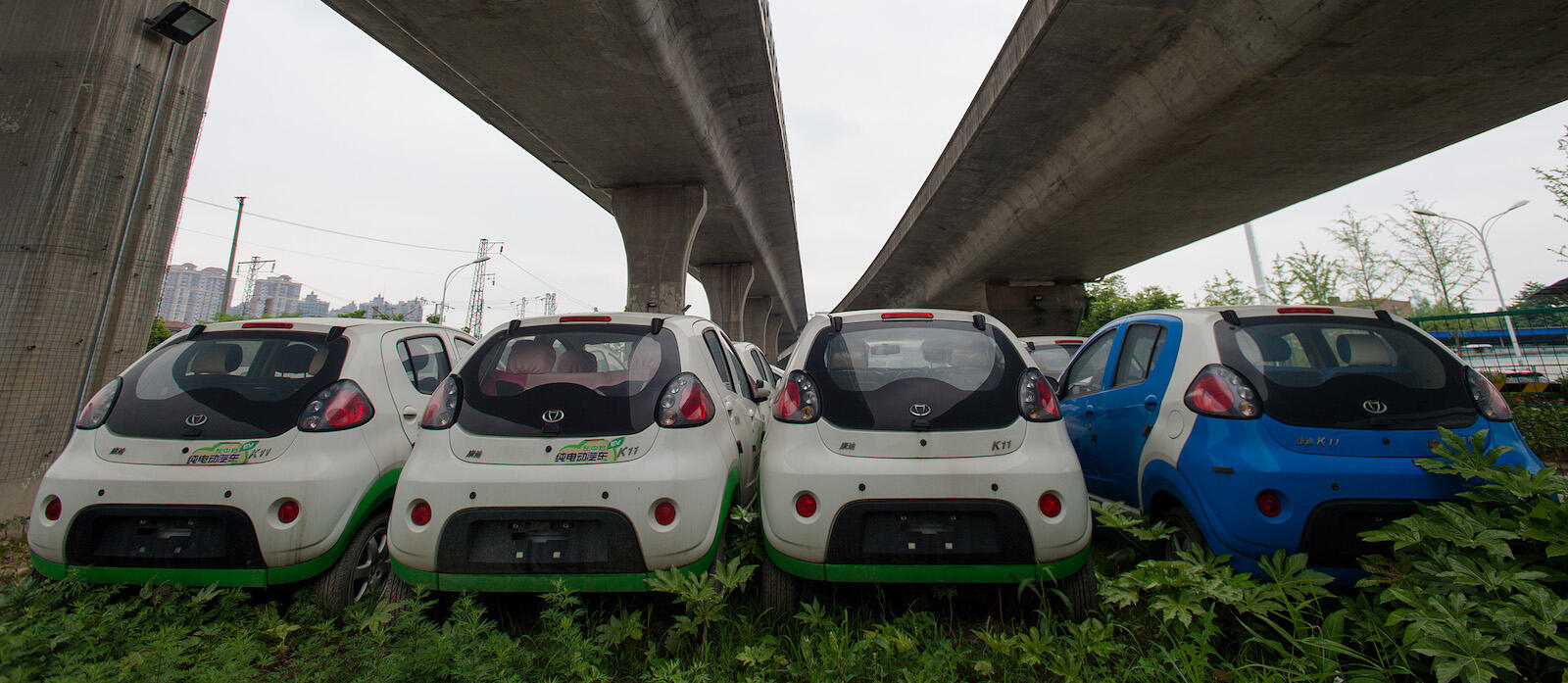 Här, under en motorvägsbro i östra Kina, står mängder av oanvända elbilar för att tillverkaren skulle kunna fuska till sig elbilssubventioner. Foto: Feature China/Barcroft Images/Barcroft Media/Getty Images