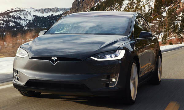 Tesla Model X kör nerför en bergsväg. (AI text)