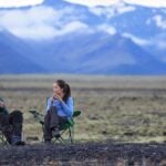 ett par sitter framför en vit fyrhjuling i ökenen (AI text)