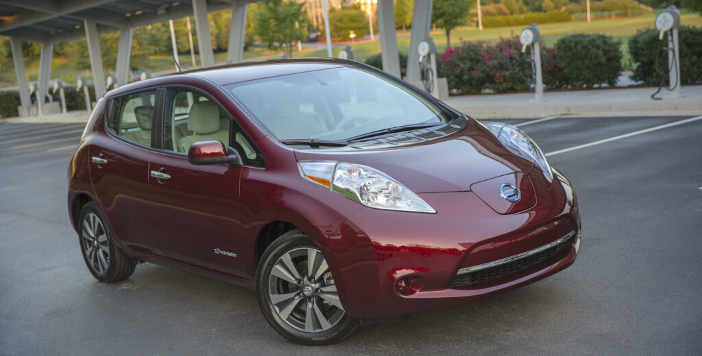 En röd Nissan Leaf parkerad på en parkeringsplats. (AI text)