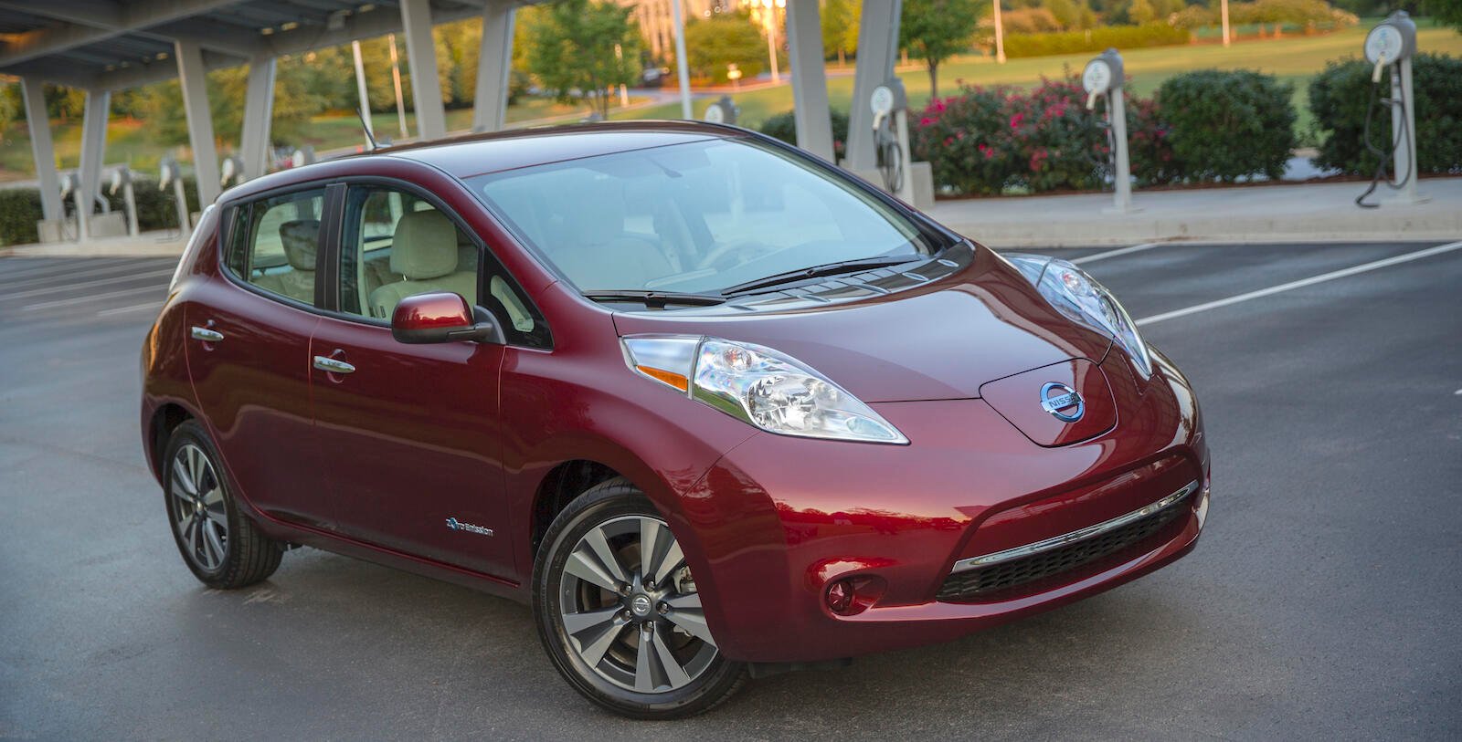En röd Nissan Leaf parkerad på en parkeringsplats. (AI text)