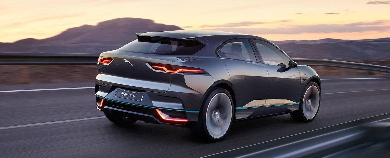 En Jaguar I Pace kör nerför en bergsväg. (AI text)