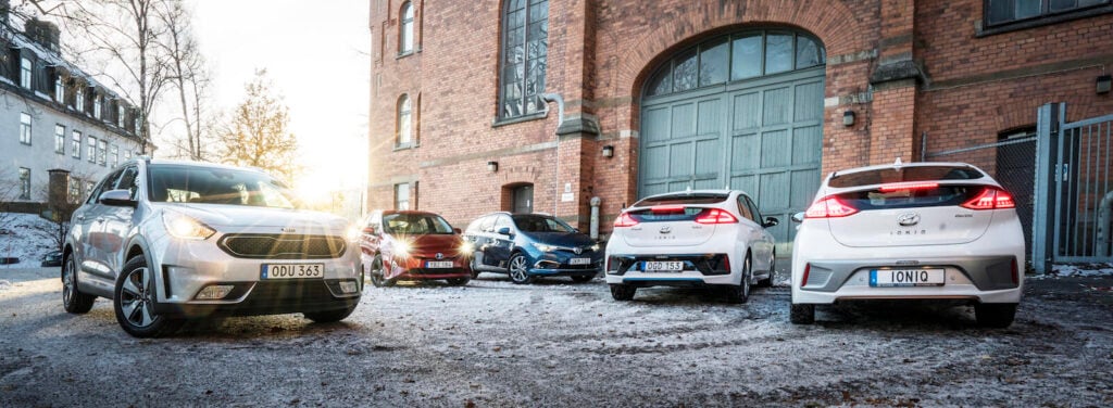 En grupp bilar parkerade framför ett byggnad. (AI text)