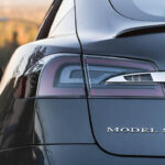 En Tesla Model S parkerad på en backe. (AI text)