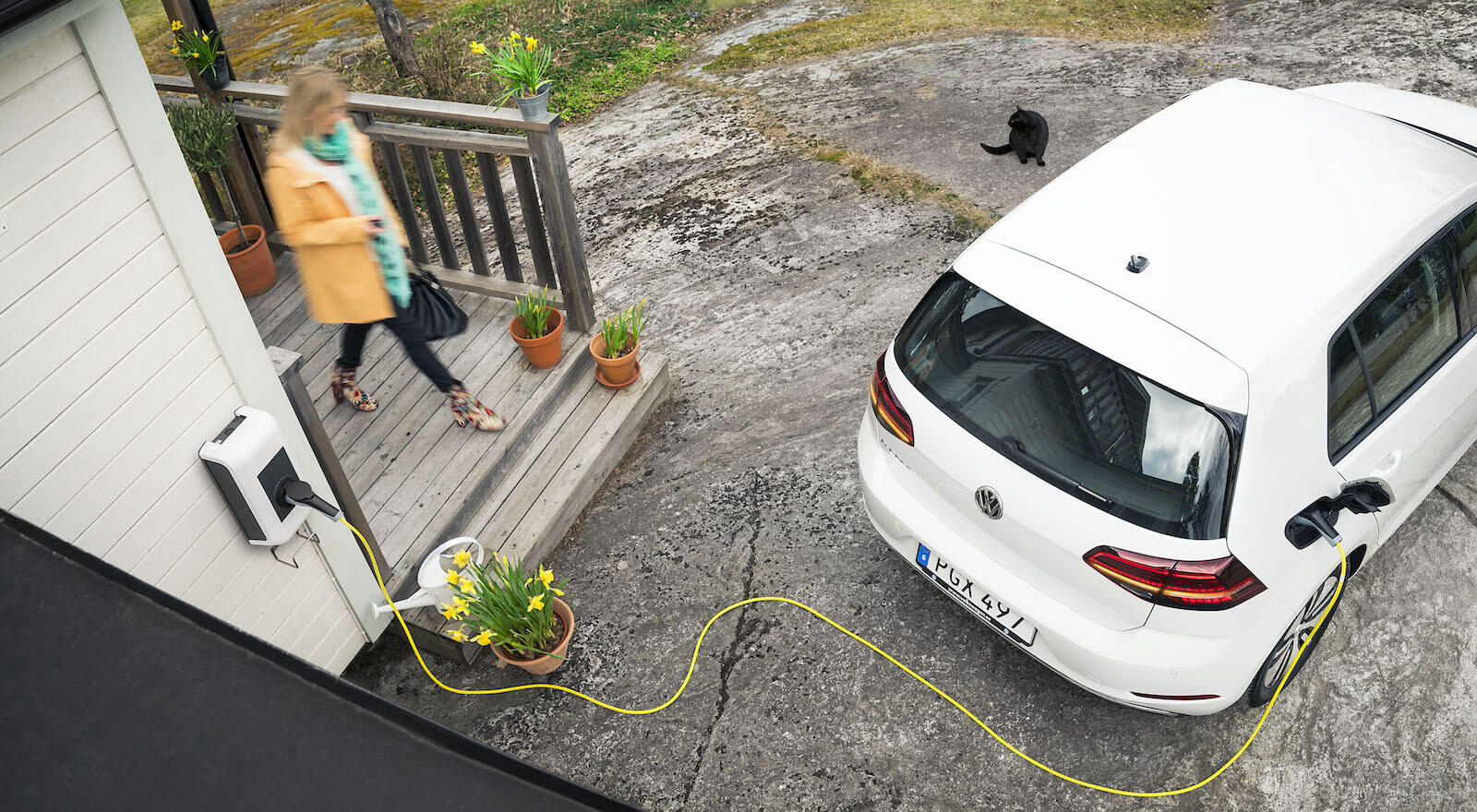 En kvinna laddar sin bil i en garage. (AI text)