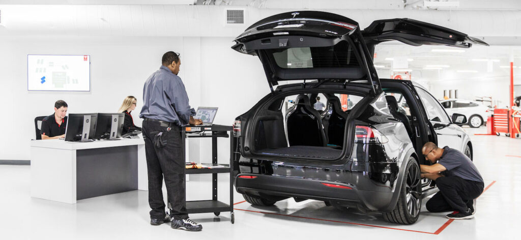 En Tesla X arbeter på i en fabrik. (AI text)