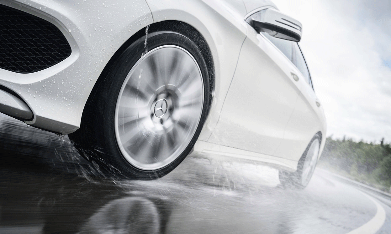 Mercedes-Benz C-klass kör på en blöt väg. (AI text)