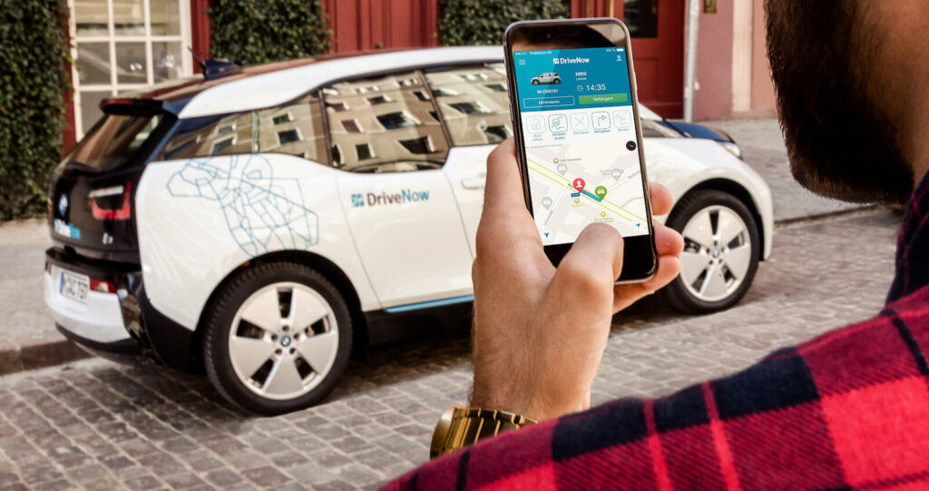 En man använder sin telefon för att kontrollera statusen på hans BMW i3. (AI text)