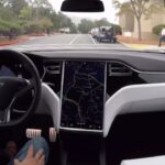 En Tesla Model S-interiör med en person i ratten. (AI text)