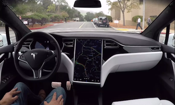 En Tesla Model S-interiör med en person i ratten. (AI text)