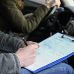 En man och kvinna sitter i en bil och tar anteckningar. (AI text)