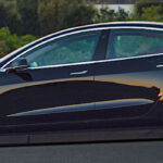 Tesla Model 3 parkerad på gatan (AI text)