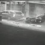 En bil kraschar in i en byggnad i en stad. (AI text)