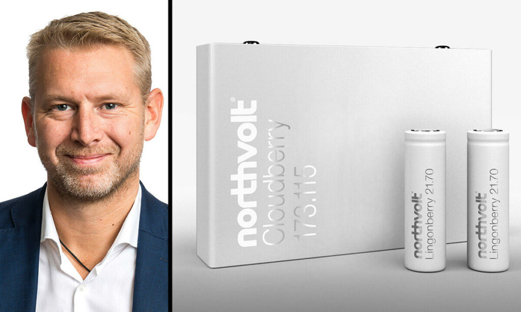 En man i kostym och slips står bredvid en låda med batterier. (AI text)