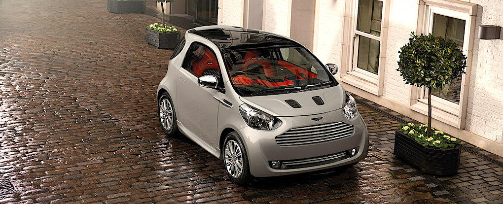 En liten bil parkerad på en ggrusad gata (AI text)