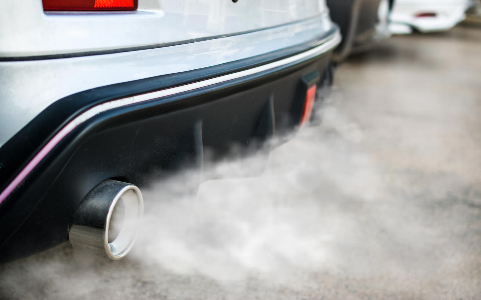 En bil med utsläppsrör som avger rök. (AI text)