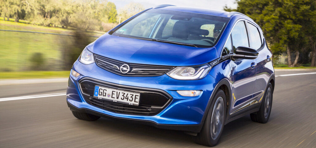 En blå Opel ECV kör nedför en landsväg. (AI text)